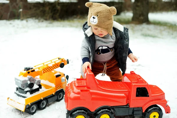 Baby jongen en speelgoed auto in de winter — Stockfoto