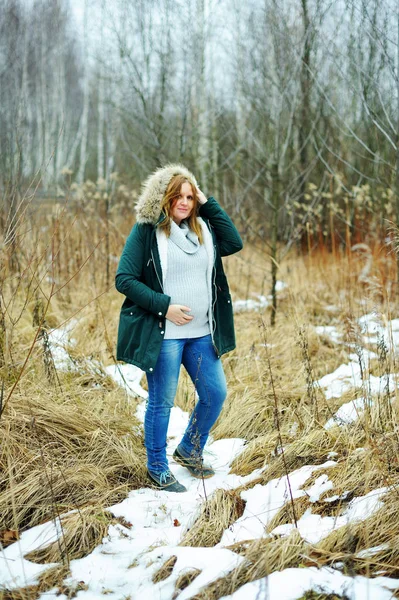 Young happy pregnant woman in snowy forest — Stock Photo, Image