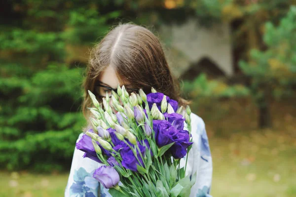 Schöne junge Mädchen mit einem Strauß Blumen — Stockfoto