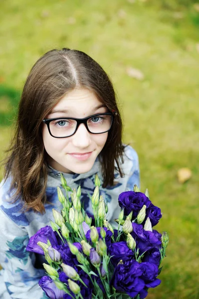 Mooi jong meisje met een boeket bloemen — Stockfoto
