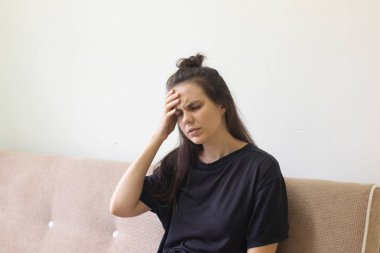 Hasta genç kadın şiddetli baş ağrısıyla evde oturuyor.