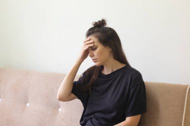 Hasta genç kadın şiddetli baş ağrısıyla evde oturuyor.