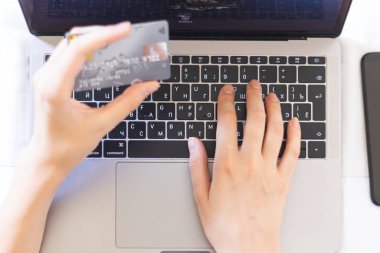 Kadın internet üzerinden satın alımları kredi kartıyla ödüyor.