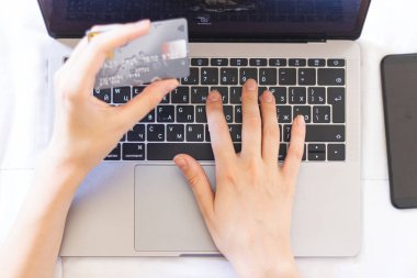 Kadın internet üzerinden satın alımları kredi kartıyla ödüyor.