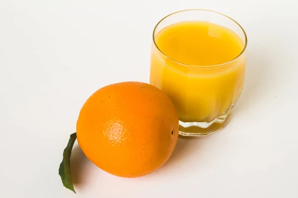 Oranges and glass of juice on a white background. — Stock Photo, Image