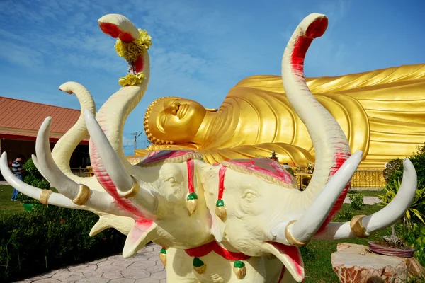 Grande statua di elefante davanti alla statua d'oro del Buddha sdraiato — Foto Stock