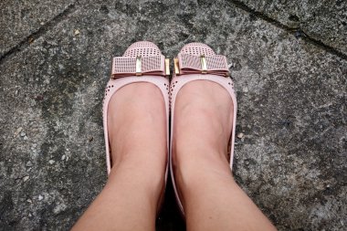 Ayaklarda deri düz ayakkabı kaldırım arka planda, üstten görünüm