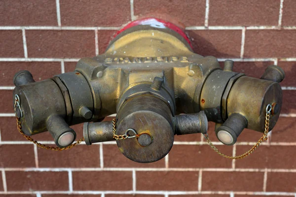 Hydrant with water hoses and fire extinguish equipment on brick — Stock Photo, Image