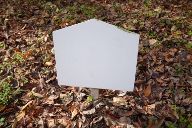 Renkli ağaç ve yaprak zemin üzerinde beyaz tabela