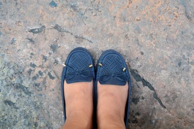 Arka plan üzerinde duran mavi deri ayakkabı giyen kadın