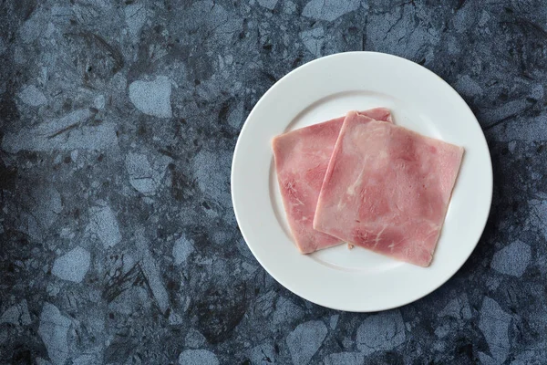 Slices of ham on the plate on marble background — Stock Photo, Image