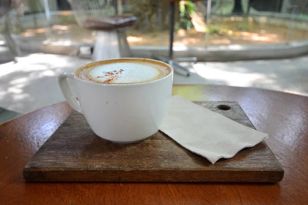 Eine Tasse heißen Cappuccino auf einem Holztisch im Café, Kaffee — Stockfoto