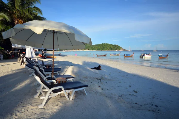Plaj sandalye ve şemsiye pastoral tropikal kum plajı üzerinde. Lipe, T
