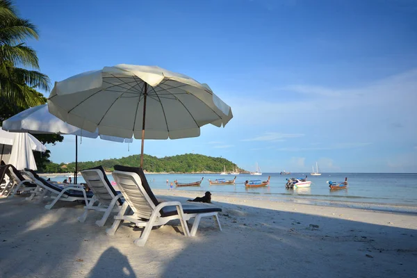 Plaj sandalye ve şemsiye pastoral tropikal kum plajı üzerinde. Lipe, T