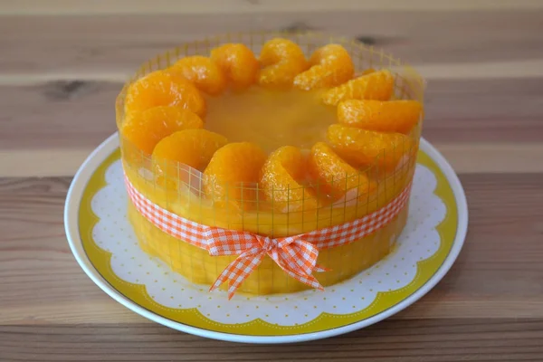 Pastel de naranja con cobertura de naranja en el fondo de madera — Foto de Stock