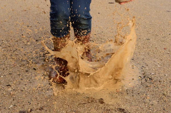 橡胶靴飞溅水坑 — 图库照片
