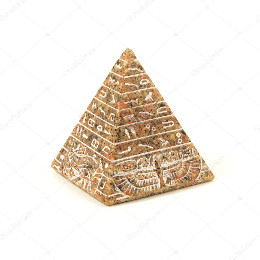 An isolated over white image of an Egyptian souviner of a handcrafted pyramid carved of stone.