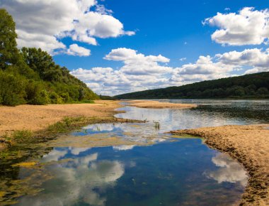 Bataklık kumlu sürüler ve ormanları ile kaplı sahilleri ile biten bir geniş nehir manzara