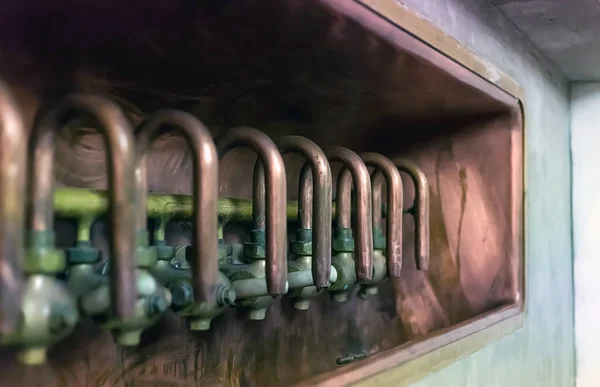 row of old shiny copper taps at the brewery production