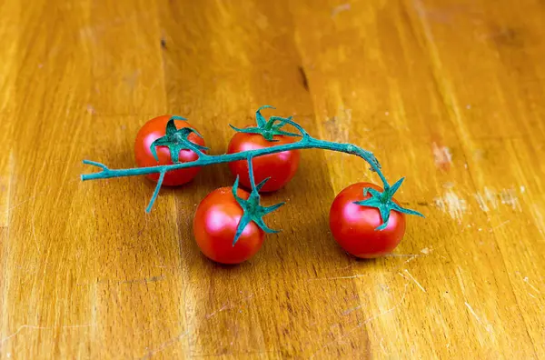 Quatro Tomates Cereja Vermelhos Ramo Fundo Madeira — Fotografia de Stock