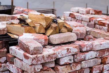 Kırmızı tuğlalı bir mangal üzerinde kıyılmış huş odun ile kireçtaşı açık şömineli