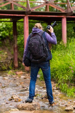Seyahat fotoğrafçı nehir banka demir köprü yoluna çim kaplı