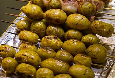 ahşap bir şiş, yalanlar üzerine padonne folyo yakın çekim ile kaplı cilt ile topaklı patates pişmiş