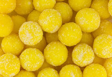 parlak sarı yuvarlak şeker şeker taneleri arka plan ile güneşli serpilir şenlikli