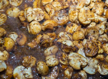 birçok doğranmış küçük petrol yarım mantar baharatlar ile bir tavada pişirilir