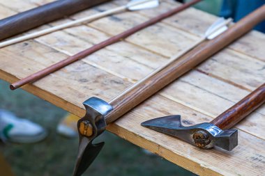 Uzun saplı bir savaş baltası ve masada keskin bir bıçak var.