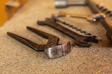 İnşaat aletleri demir uçlar, ingiliz anahtarı ve matkapla ahşap bir tahtaya yakın çekim