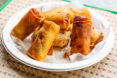 Karides ve sebzelerle doldurulmuş kızarmış börek, Asya Vietnam ve Tayland yemeği beyaz bir tabakta yatıyor.