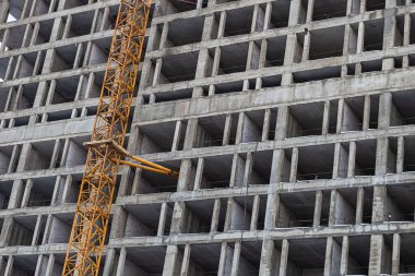 İnşaatın başlangıcı beton tabanlı, sarı vinci olan yüksek bir bina.