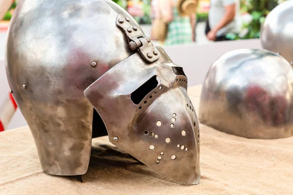 old iron helmet with visor protection of medieval warrior rider lies on a wooden table