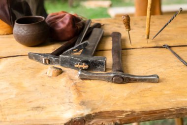 Kazma aletleri seti, çekiç ahşap bir masanın üzerinde bir tenteye karşı duruyor.