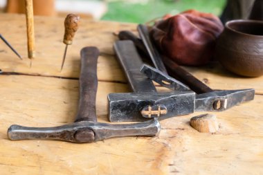 Eski ve eski bir çekiç ve kazma kırsal bir masada yatıyor.