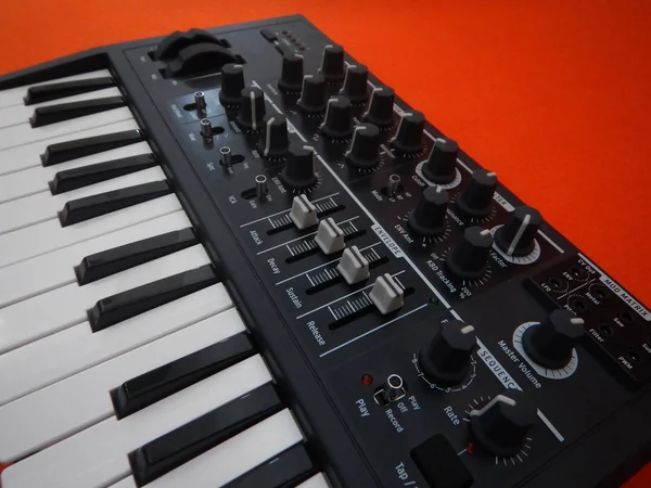 Elektronisch muziekinstrument of audio mixer of geluid equalizer op een oranje achtergrond (analoge modulaire synthesizer) — Stockfoto