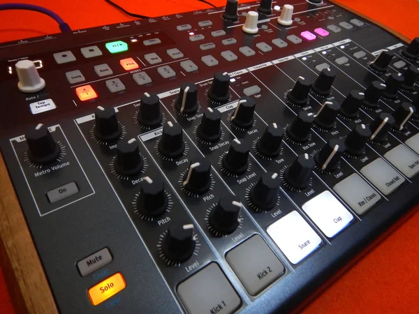 Elektronisch muziekinstrument of audio mixer of geluid equalizer op een oranje achtergrond met patch kabels en hoofdtelefoons (analoge modulaire synthesizer) — Stockfoto