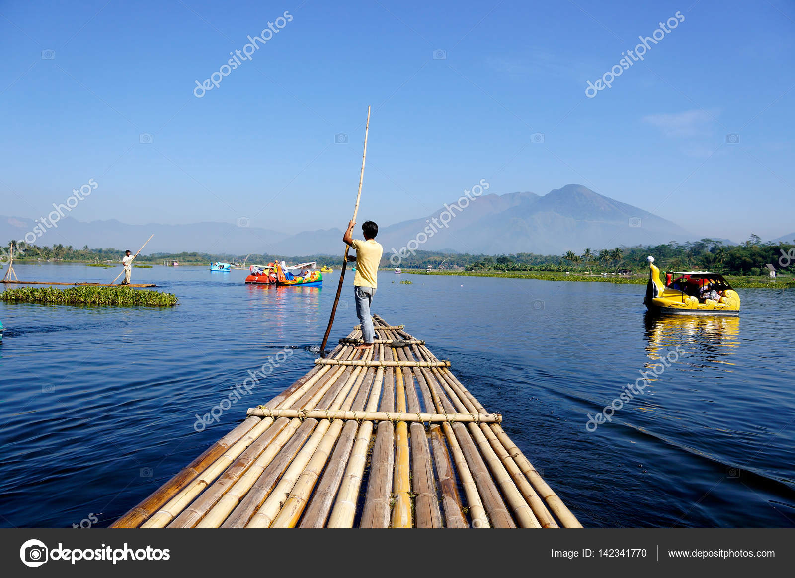Man rowing a raft on the river in Indonesia. Stock Photo by ©Todikromo