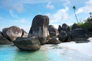 Natural rock formation on the blue turquoise colored seashore and white sand beach. clipart