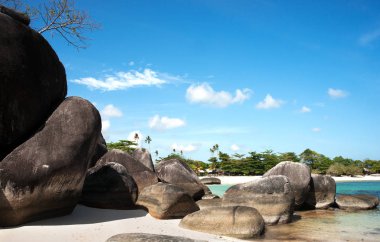 Öğleden sonra ve arka plan, palmiye ağaçları ile beyaz kum plaj beyaz kum plaj kıyısında doğal kaya oluşumu.