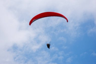 Kırmızı paraşüt eğlenceli ve heyecan için kayma ile mavi gökyüzünde bir Yamaçparaşütü.