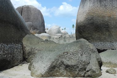 Doğal kaya oluşumu beyaz kum plaj ve yeşil palmiye ağaçları Belitung Adası, Endonezya.