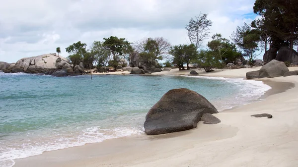 Formation de roches naturelles sur le littoral bleu turquoise et la plage de sable blanc avec des plantes et des arbres en arrière-plan à Belitung Island, Indonésie . — Photo