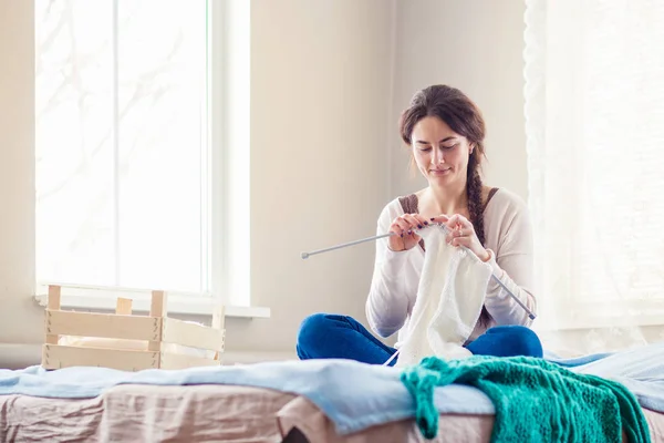 Jonge vrouw breien thuis in de winter — Stockfoto