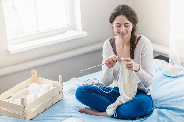 冬に家で編み物をする若い女 — ストック写真