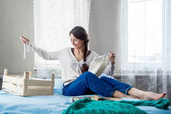 Jonge vrouw breien thuis in de winter — Stockfoto