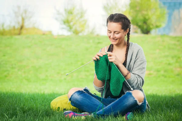 woman  knitting a green sweater