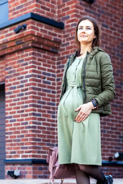 Zwangere brunette in een groene jurk — Stockfoto