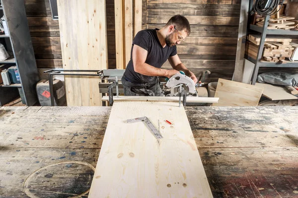 Mann sägt mit Kreissäge ein Holz — Stockfoto